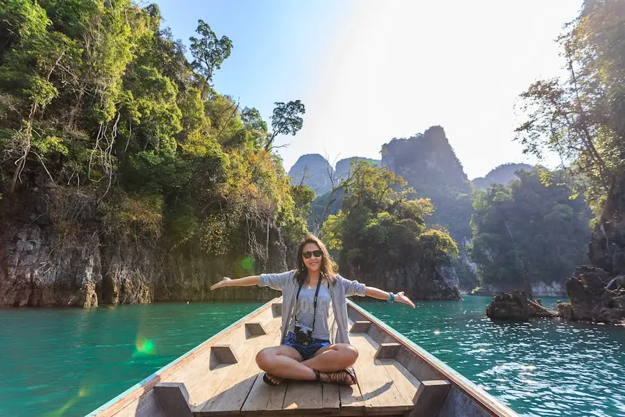 Asian woman relishing a serene boat journey through the lush karst landscape of Thailand's Khlong Sok.